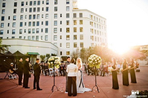 A simple arrangement of two pedestals of vibrant florals sets the space in an elegant way, on the terrace of El Cortez, downtown San Diego. Photo by True Photography